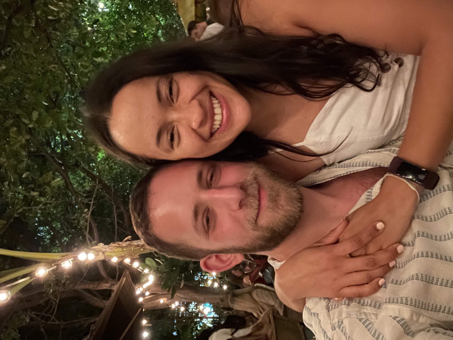 Salma and Eric under string lights at night in Miami